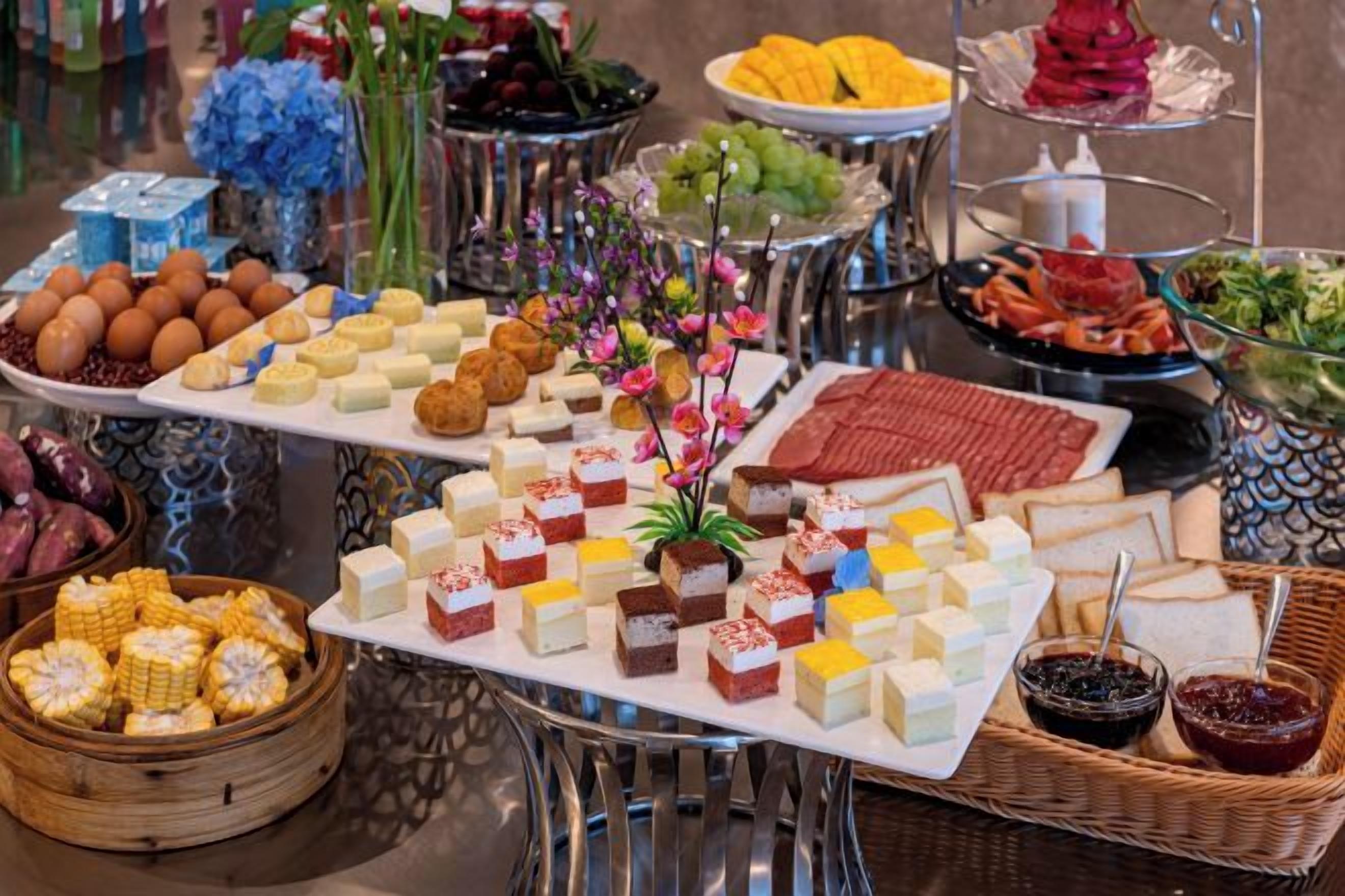 En buffet med diverse retter og en dekorativ midtpunkt.