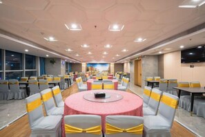 A conference room with round tables, chairs, and a large screen. - Hangzhou Yuecheng Audio & Video International Hotel (Boao Xinhan Road Subway Station) (Hangzhou)