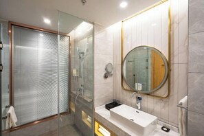 A modern bathroom with a glass-enclosed shower, a round mirror, and a white sink. - Hangzhou Yuecheng Audio & Video International Hotel (Boao Xinhan Road Subway Station) (Hangzhou)