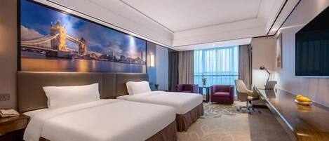 A hotel room with two beds, a desk, a chair, a TV, and a large window.