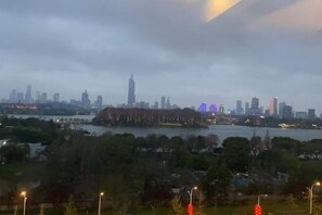 A city skyline with a prominent tower, surrounded by water and greenery. - Qingmu Hotel (Nanjing Xinzhuang Metro Station) (Nanjing)