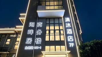 Um edifício de hotel com sinalização iluminada indicando 'Hotel' e 'Hotel Business' na fachada.