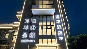 A hotel building with illuminated signage indicating 'Hotel Business' and 'Hotel 7F'.
