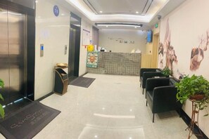 A hotel reception area with a reception desk, seating area, and a reception counter. - Qingmu Hotel (Nanjing Xinzhuang Metro Station) (Nanjing)