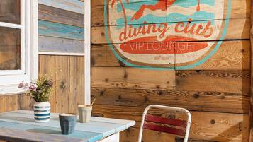 Ein Holzinterieur mit einem Tisch, Stühlen und einem Wandschild mit der Aufschrift "Bächte diving club".