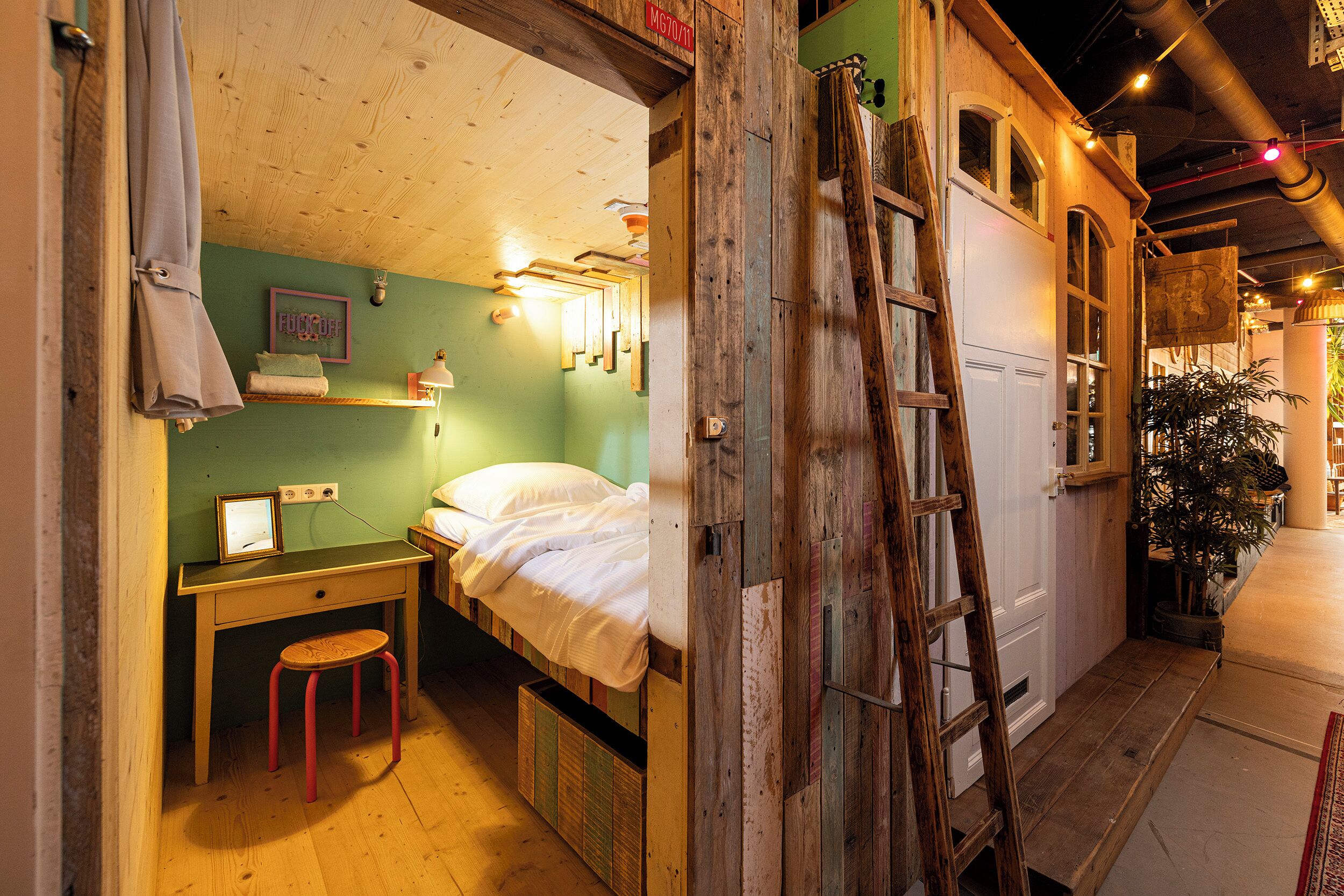 Una habitación pequeña y acogedora con cama, escritorio y una escalera.