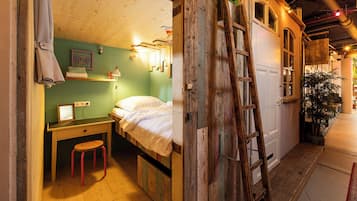 Una habitación pequeña y acogedora con cama, escritorio y una escalera.