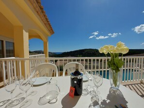 A table set for dining with a view of a pool and hills in the background. - Casa Françoise (L'Escala)