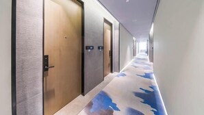 A hotel hallway with doors, a patterned carpet, and a modern design. - Homeinn Fairyland Hotel (Linhai Yintaicheng) (Linhai)