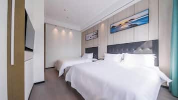 Una habitación de hotel con dos camas, un televisor de pantalla plana, paneles de madera y obras de arte.