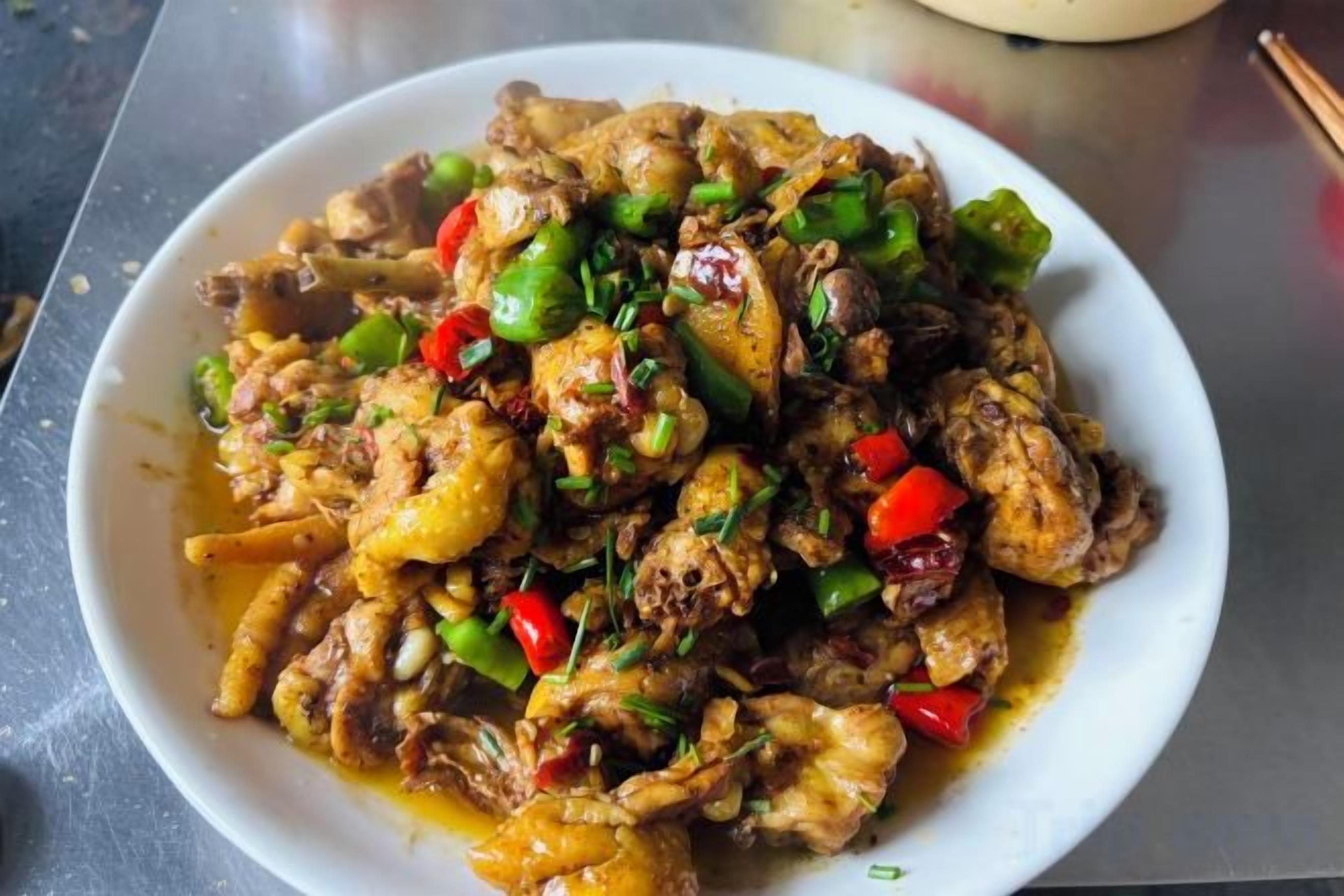 A bowl of stir-fried chicken with vegetables.