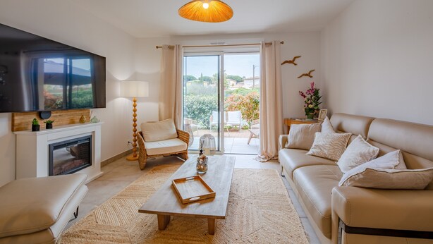 Una sala de estar moderna con chimenea, sofá, mesa de centro y televisor.