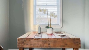 Een rustieke houten tafel met een potorkidee en een kleine vaas.