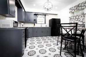 Enjoy cooking and dining in this well-equipped kitchen with a central island, microwave, coffee maker, and refrigerator.