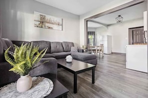 Una sala de estar moderna con un sofá, una mesa de centro y una planta decorativa.