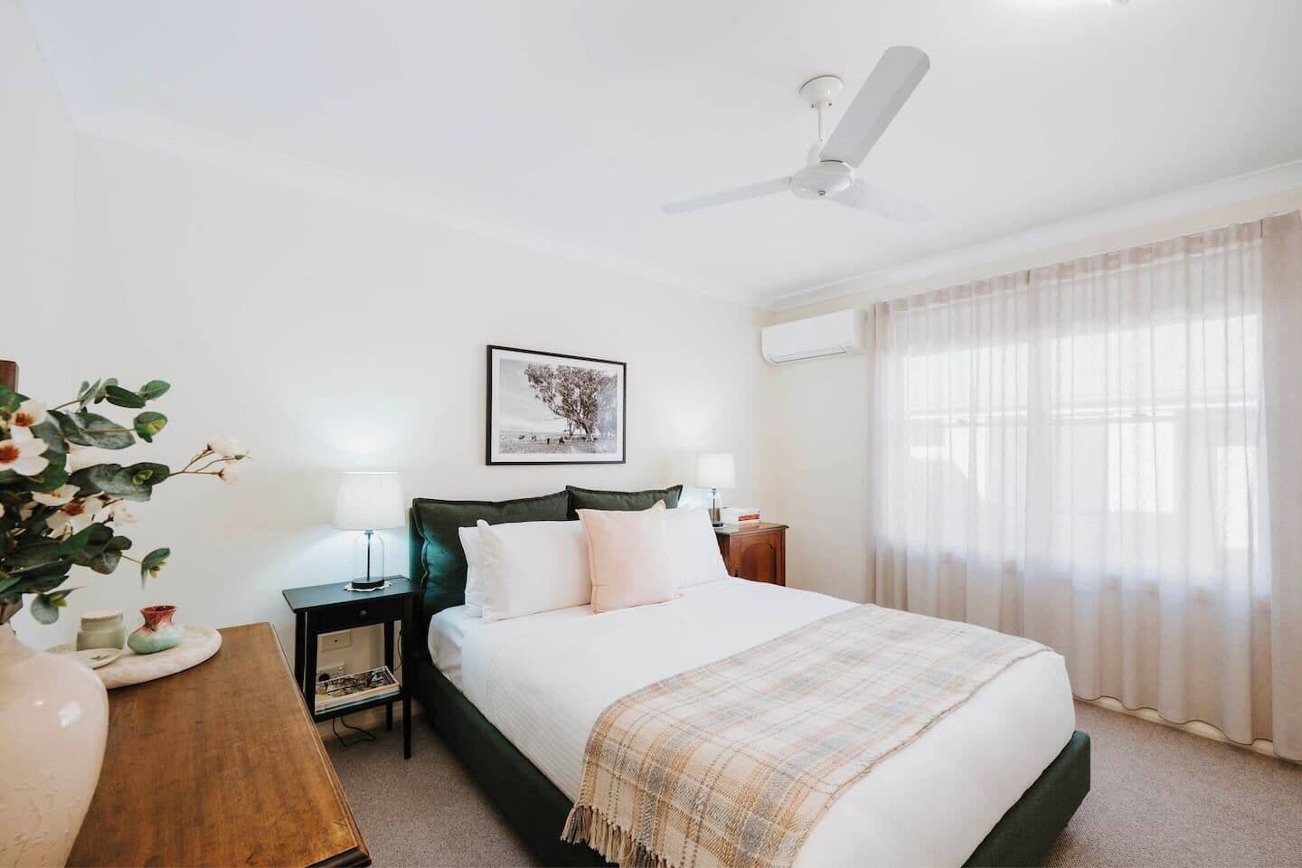 Recharge in the primary bedroom with a queen-size bed dressed in crisp white linen, split-system air conditioning and heating, plus a ceiling fan for extra breezes.