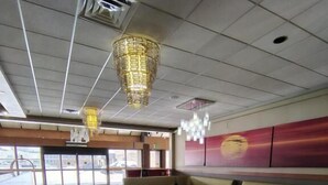 Eine geräumige Lobby mit einer großen Couch, einem gemusterten Teppich und einem modernen Kronleuchter.