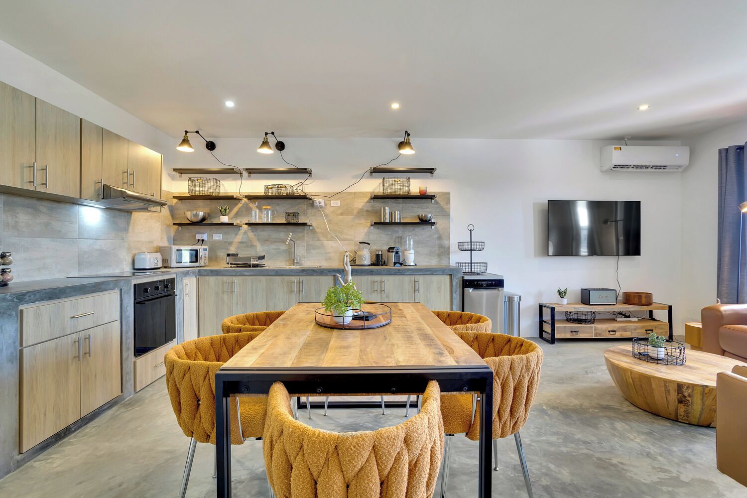 A modern kitchen with wooden cabinets, a central island, and pendant lighting.