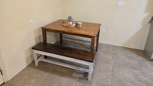 A small wooden table with a bench, a potted plant, and a tray with jars on a plain wall. - Charming 2-bedroom apartment in Mercedes near the Outlets (Mercedes)