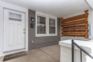 Enter through the welcoming door, featuring a window with a grid pattern, into a cozy space.