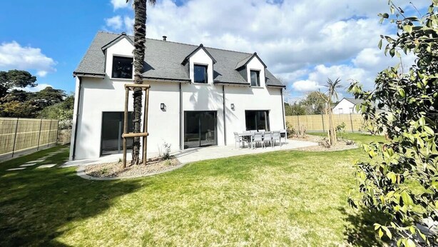 A modern two-story house with a patio, a palm tree, and a fenced yard. - Luxury Maison d'Architecte neuve de standing (Larmor-Baden)