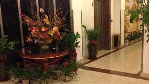 A hallway with a large decorative vase filled with flowers and potted plants. - Green Tree Alliance Hotel (Shanghai East Jinxiu Road) (Shanghai)