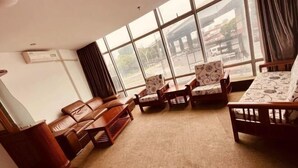 A room with large windows, a sofa, armchairs, and a patterned table. - Green Tree Alliance Hotel (Shanghai East Jinxiu Road) (Shanghai)