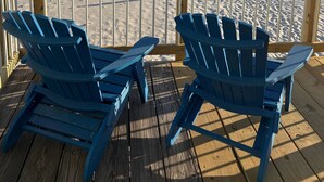 Two blue Adirondack chairs on a wooden deck overlooking a sandy beach with a clear sky. - BEACHFRONT w heated pool, steps to sand. Winter discounts Bath remodel 2 BR 1 BA (Gulf Shores)