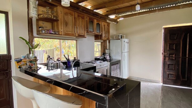 Een moderne keuken met een marmeren eiland, houten kastjes en een roestvrijstalen spoelbak.