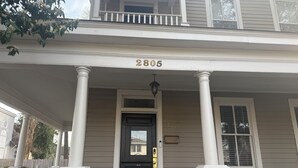 A two-story house with a porch, columns, and a black front door. - Charming Century Old 3-bedroom house with WiFi and AC in fantastic Columbia (Columbia)