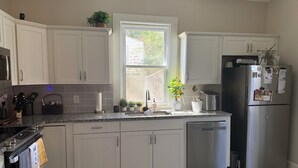 A modern kitchen with white cabinets, a stainless steel refrigerator, and a window providing natural light. - Charming Century Old 3-bedroom house with WiFi and AC in fantastic Columbia (Columbia)