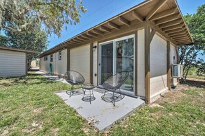 Guests can enjoy a covered patio with a concrete floor and two chairs.