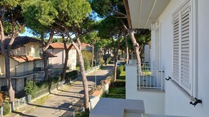 Un quartier résidentiel avec un bâtiment blanc, des arbres et un ciel dégagé.