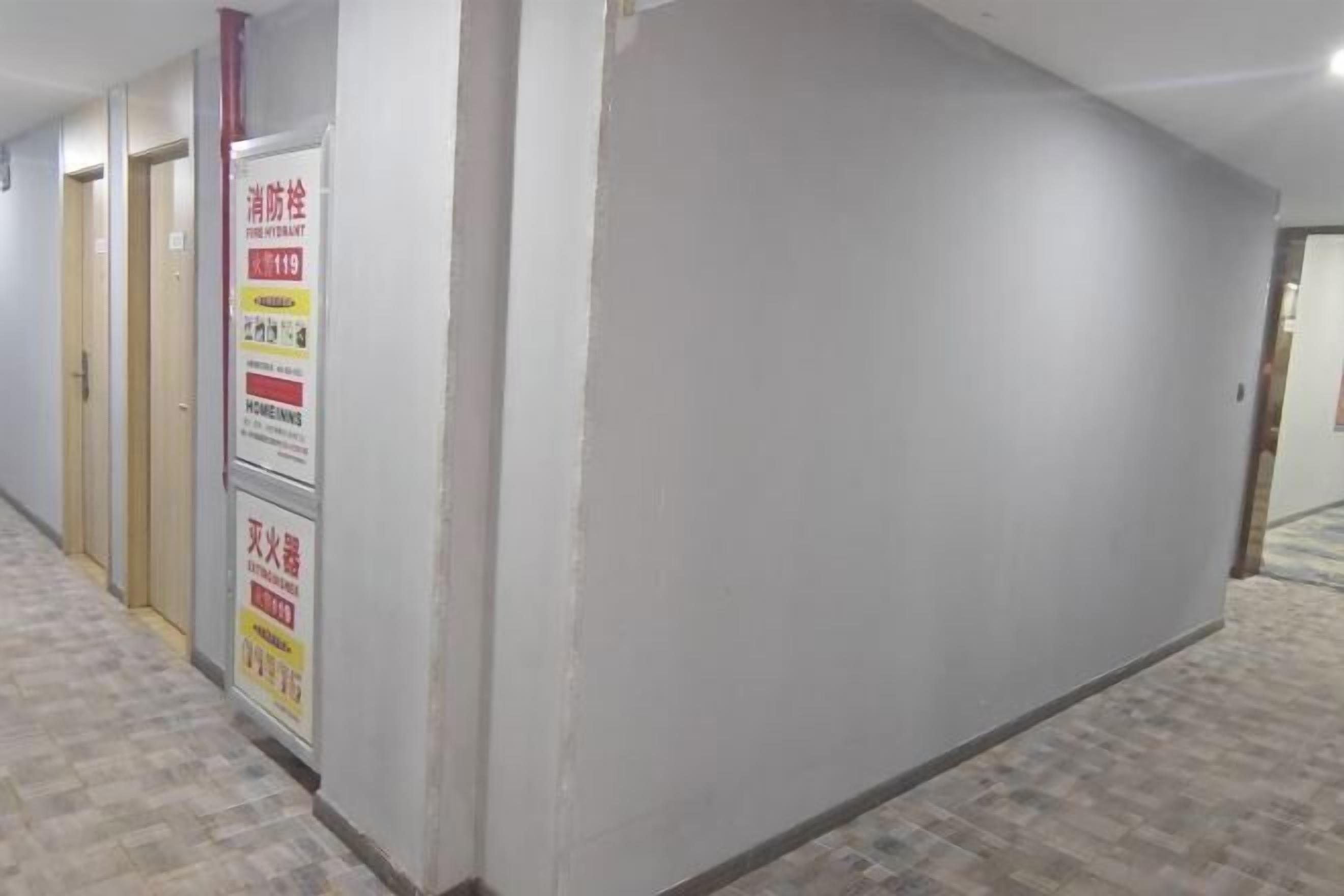 A hallway with tiled flooring and a wall-mounted fire extinguisher sign.