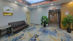A lobby with a ceiling mural, a brown leather sofa, a round table, and potted plants. - Yiju Hotel (Xi'an Bell and Drum Tower Ximen Children's Hospital Branch) (Xi'an)