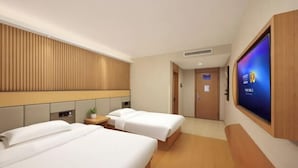 A hotel room with two beds, a TV, a wooden headboard, and a small table with a plant. - Super 8 Preferred Hotel（Mentougou Xinqiao Street Branch Conversion） (Beijing)