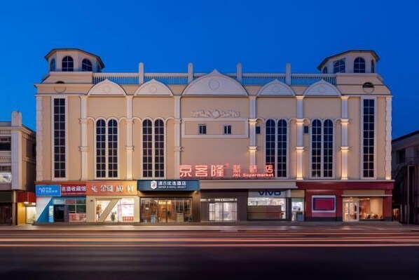 A multi-story building with a central entrance, large windows, and signage for a supermarket and other businesses. - Super 8 Preferred Hotel（Mentougou Xinqiao Street Branch Conversion） (Beijing)