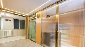 A modern hallway with a glass door, a sign indicating the room number, and a radiator on the wall. - Super 8 Preferred Hotel（Mentougou Xinqiao Street Branch Conversion） (Beijing)