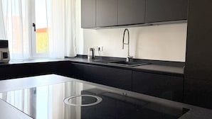 A modern kitchen with a built-in stove, a sink, and a window with curtains. - SE156 – Senigallia, three-room apartment a few steps from the sea (Senigallia)