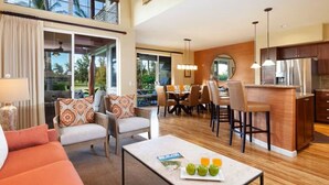 A modern living room with a sofa, chairs, a coffee table, and a dining area with a table and chairs.