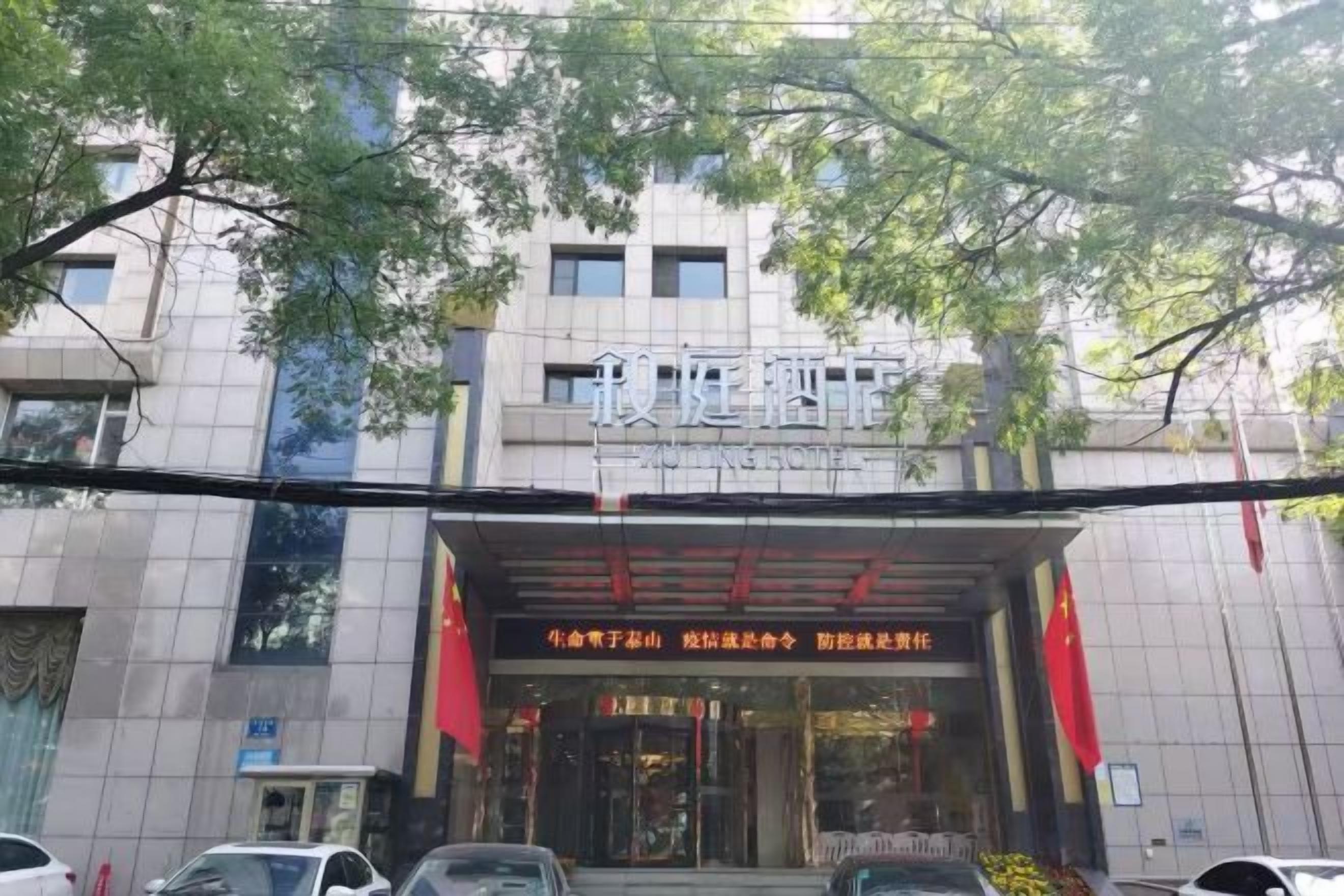 Un edificio con un cartel que dice 'Hotel' y una bandera roja sobre la entrada.