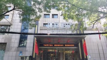 Un edificio con un cartel que dice 'Hotel' y una bandera roja sobre la entrada.