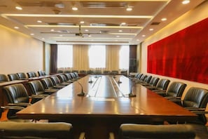 A conference room with a long table, multiple chairs, and a red accent wall. - Xuting Hotel (Taiyuan Xinmin North Street) (Taiyuan)