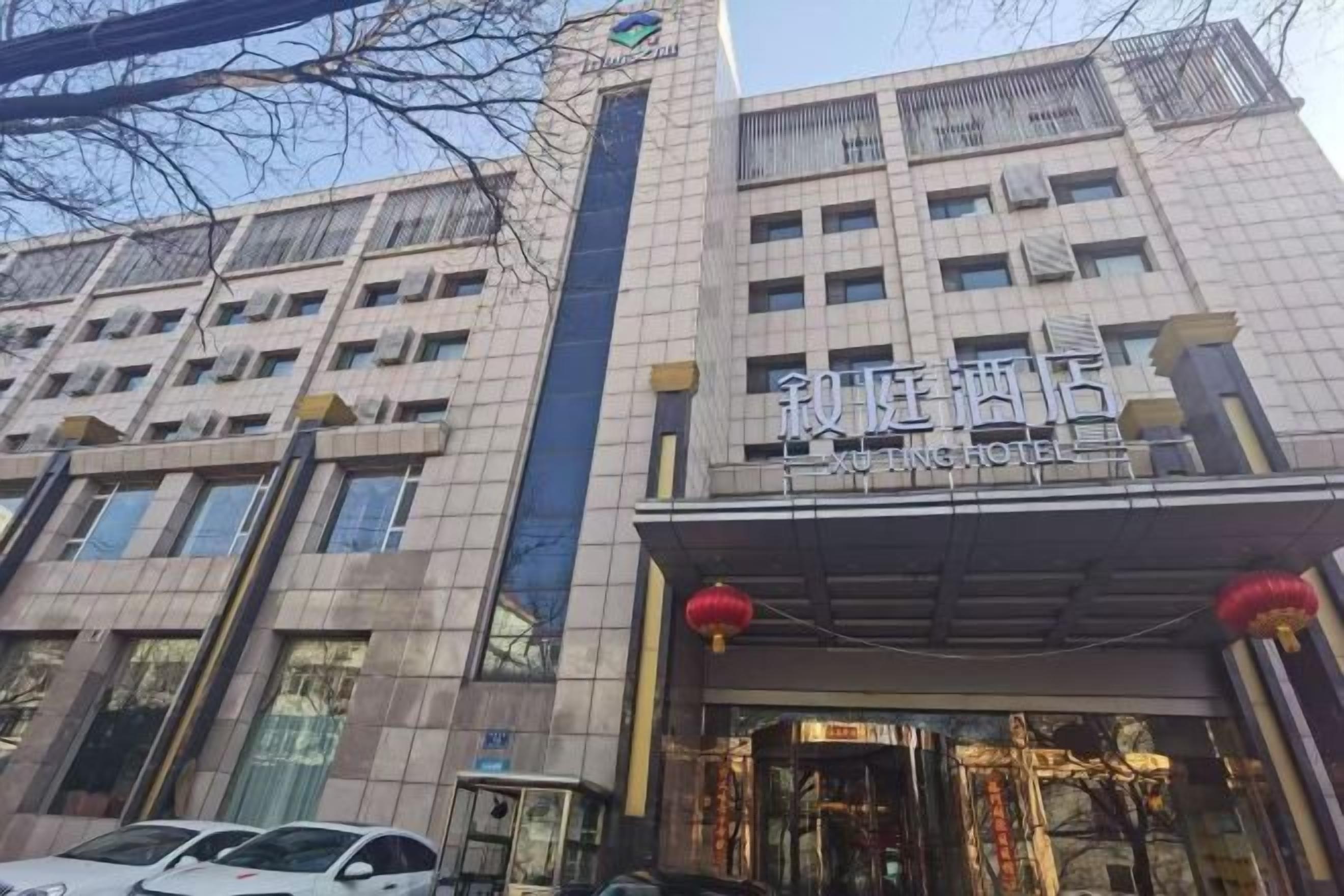A hotel with a modern facade, multiple floors, and a prominent entrance with a sign.
