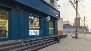 A building with a blue facade and a sign that reads 'OBACCO'.