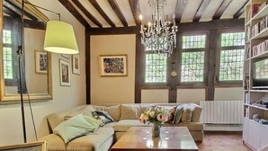 A cozy living room with a sectional sofa, a coffee table, and a chandelier.