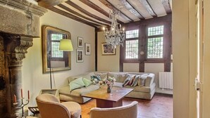 A cozy living room with a sofa, chairs, a coffee table, and a chandelier.
