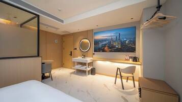 Una habitación de hotel moderna con una cama, un escritorio, una silla, un espejo redondo y un cuadro grande con una vista urbana.