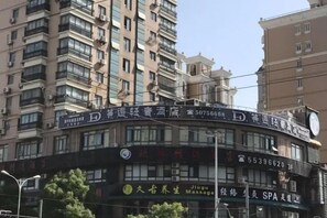 A multi-story building with signage for a hotel and a massage parlor. - Overhere Light Luxury Hotel (Shanghai Wujiaochang Fudan University) (Shanghai)
