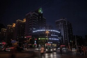 A nighttime cityscape with illuminated buildings and a busy intersection. - Overhere Light Luxury Hotel (Shanghai Wujiaochang Fudan University) (Shanghai)